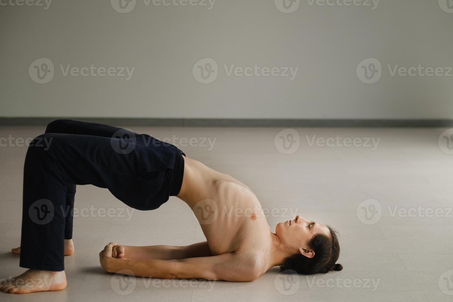 a man with a naked torso does yoga in the gym. the concept of a healthy lifestyle photo