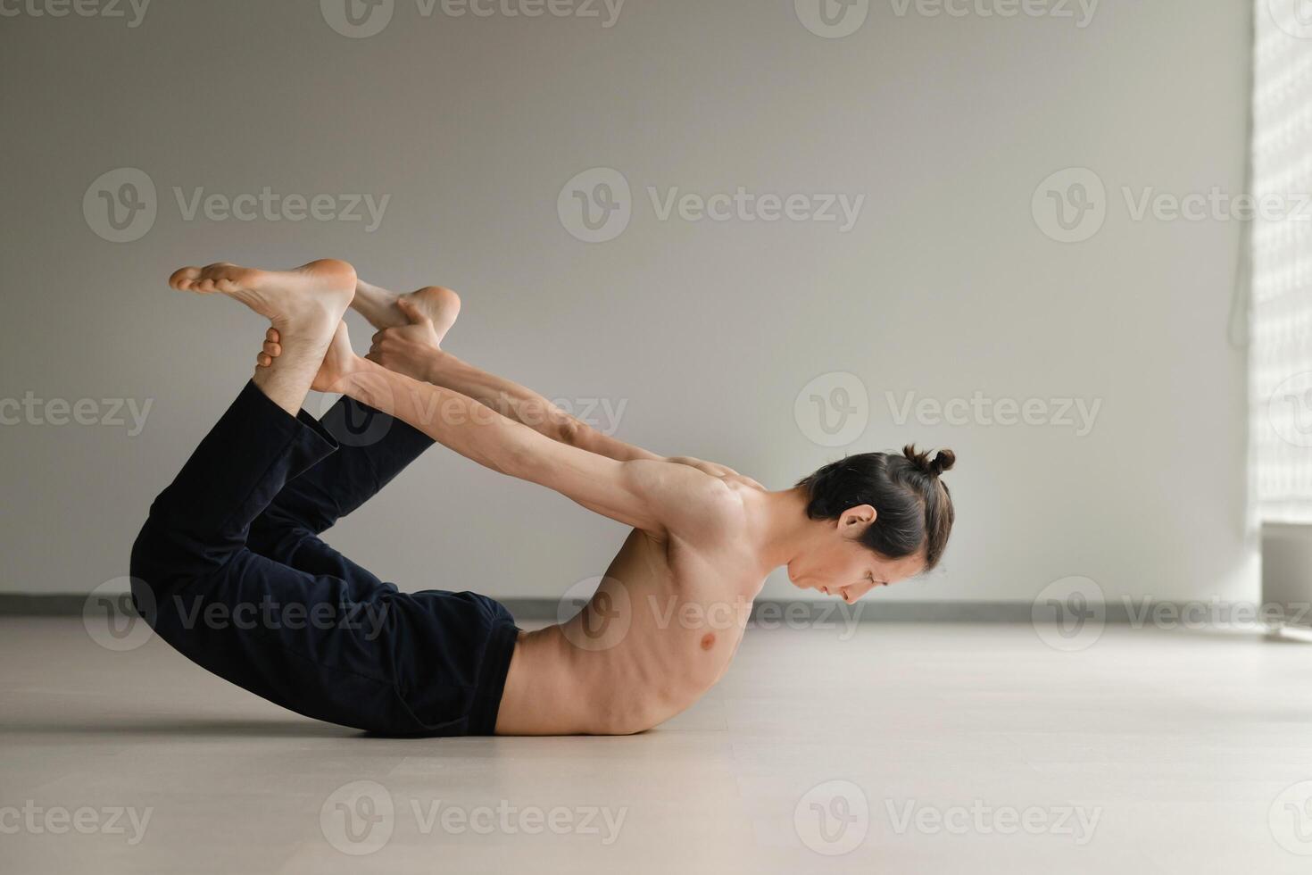 a man with a naked torso does yoga in the gym. the concept of a healthy lifestyle photo