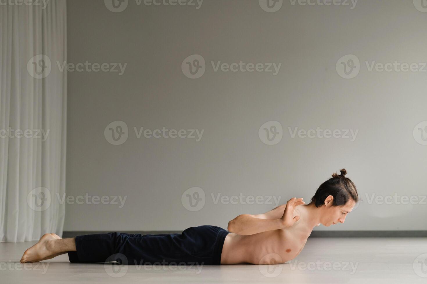 a man with a naked torso does yoga in the gym. the concept of a healthy lifestyle photo