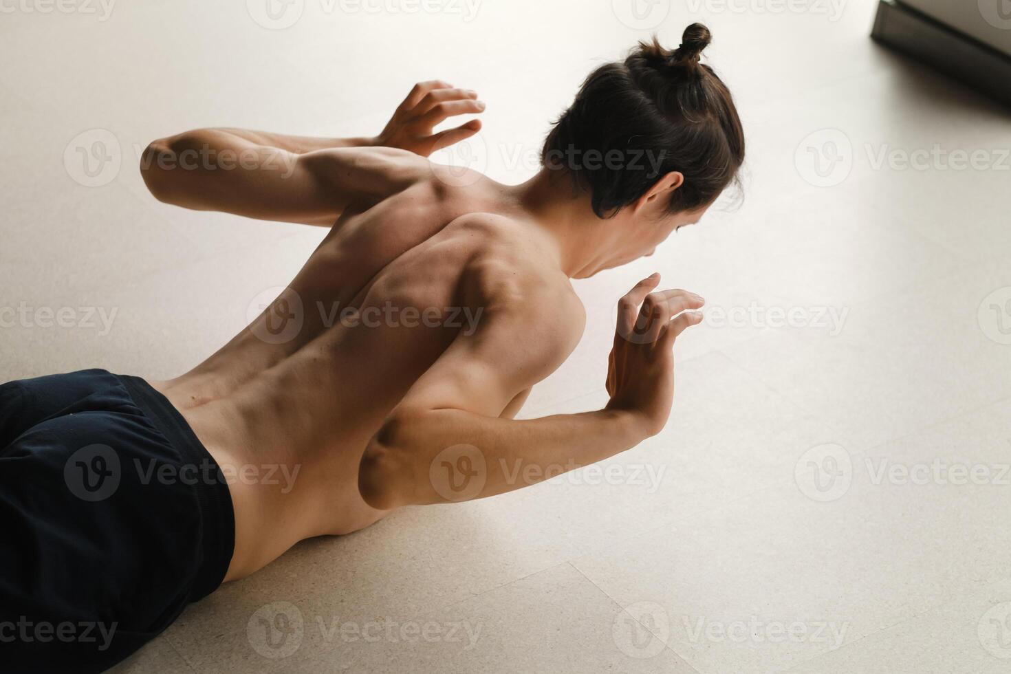 a man with a naked torso does yoga in the gym. the concept of a healthy lifestyle photo