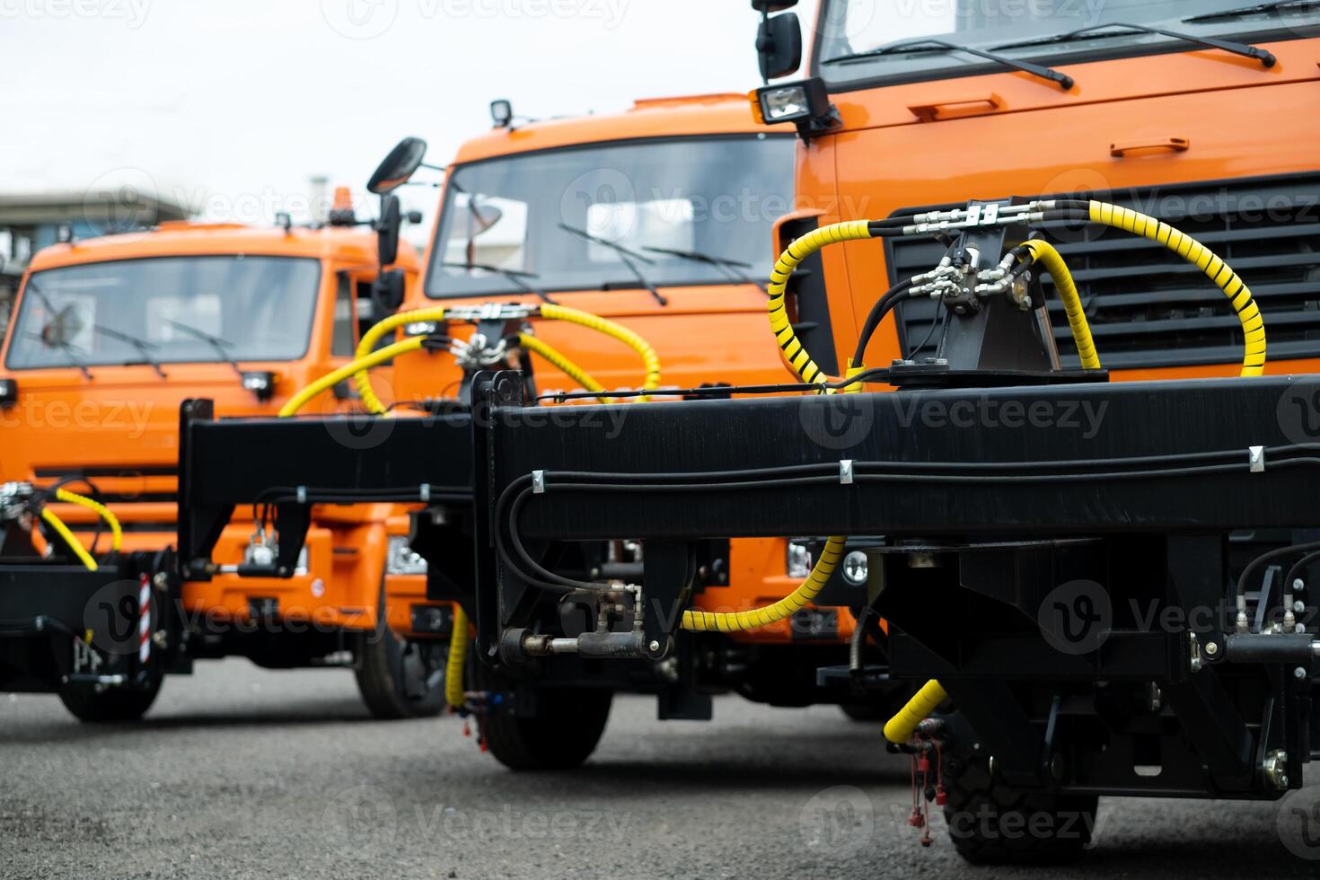 New Trucks standing in a row on an orange-colored street photo