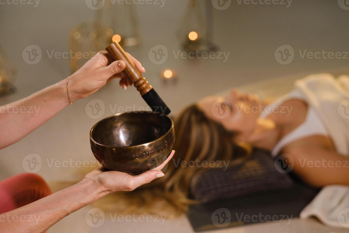 A girl lying on the floor relaxes to the sounds of a Tibetan bowl in the fitness room photo