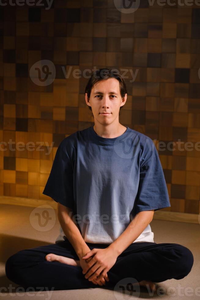 a man in a sports uniform does yoga in a fitness room. the concept of a healthy lifestyle photo
