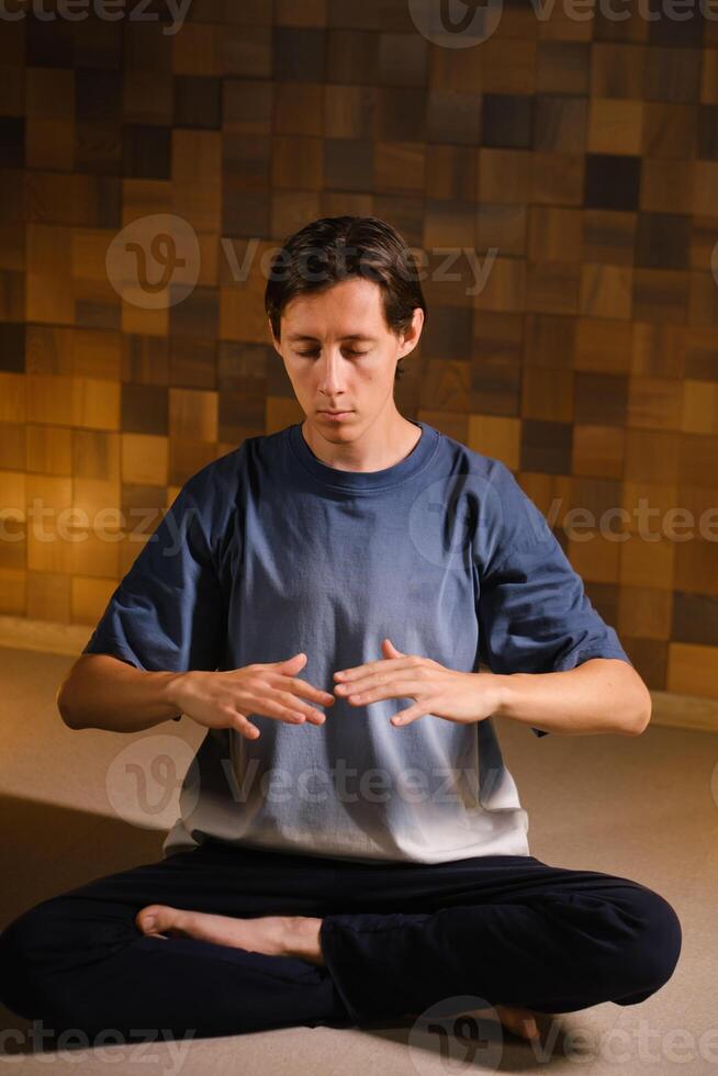 a man in a sports uniform does yoga in a fitness room. the concept of a healthy lifestyle photo