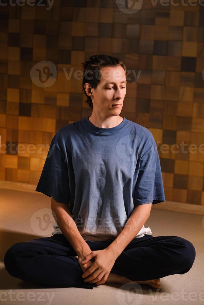 a man in a sports uniform does yoga in a fitness room. the concept of a healthy lifestyle photo