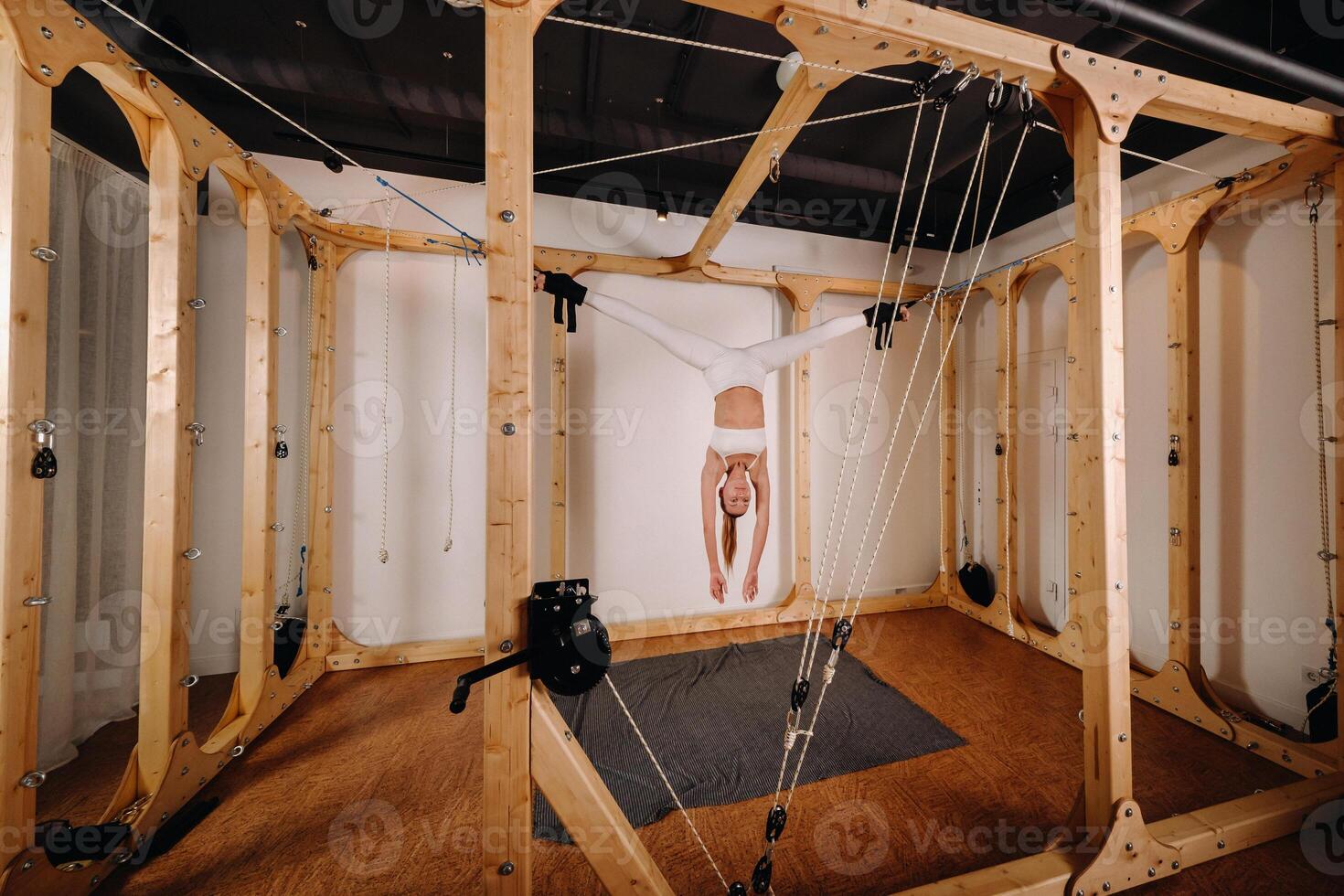 A girl in a sports uniform does exercises on a simulator for stretching the human body photo
