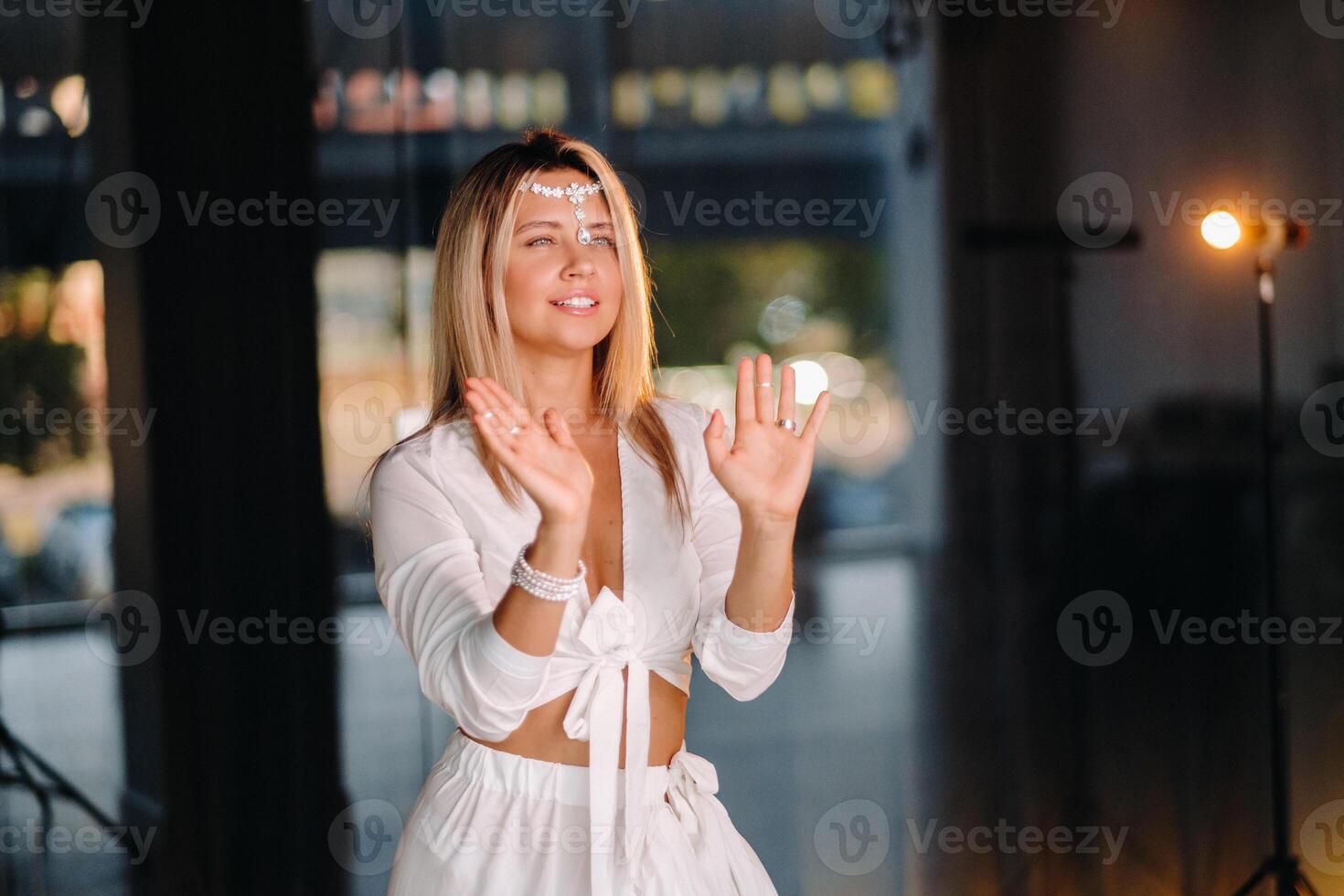 Beautiful smiling girl in a white dress dancing in the gym photo