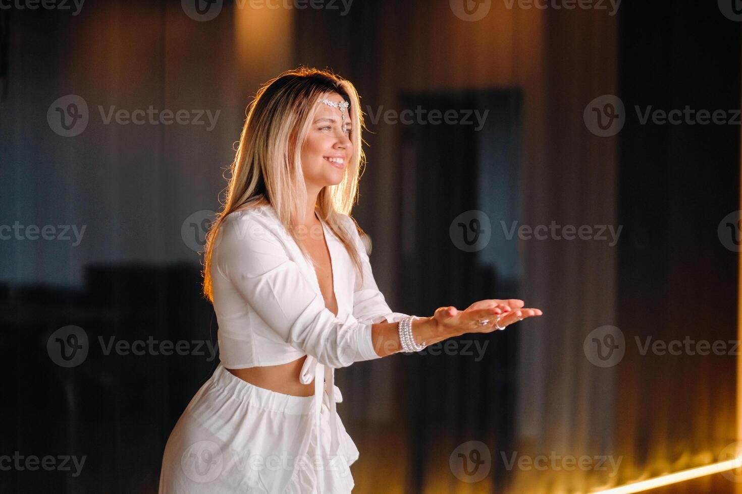 Beautiful smiling girl in a white dress dancing in the gym photo