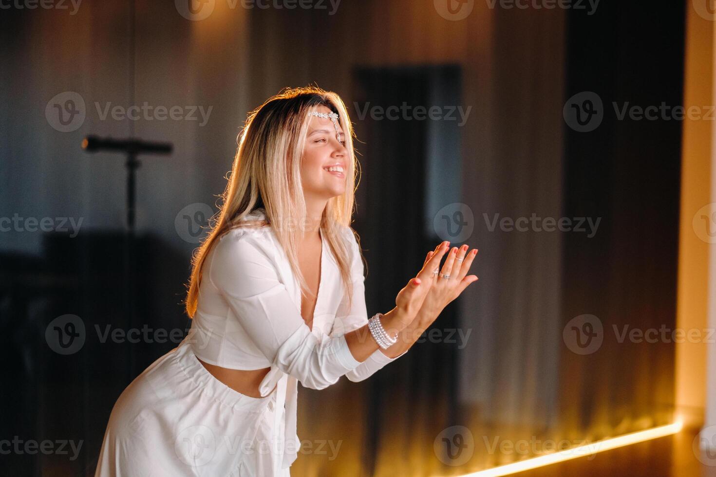 Beautiful smiling girl in a white dress dancing in the gym photo