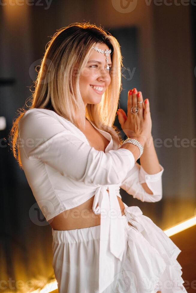 Beautiful smiling girl in a white dress dancing in the gym photo