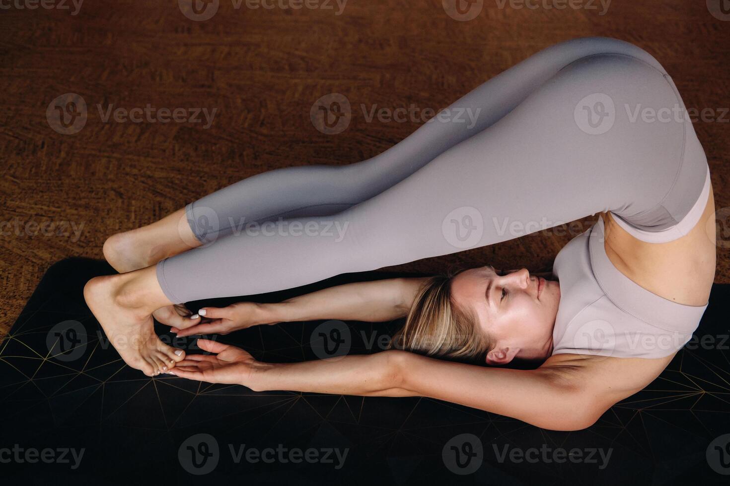The girl does yoga. A woman in sports clothes does yoga exercises in the gym photo