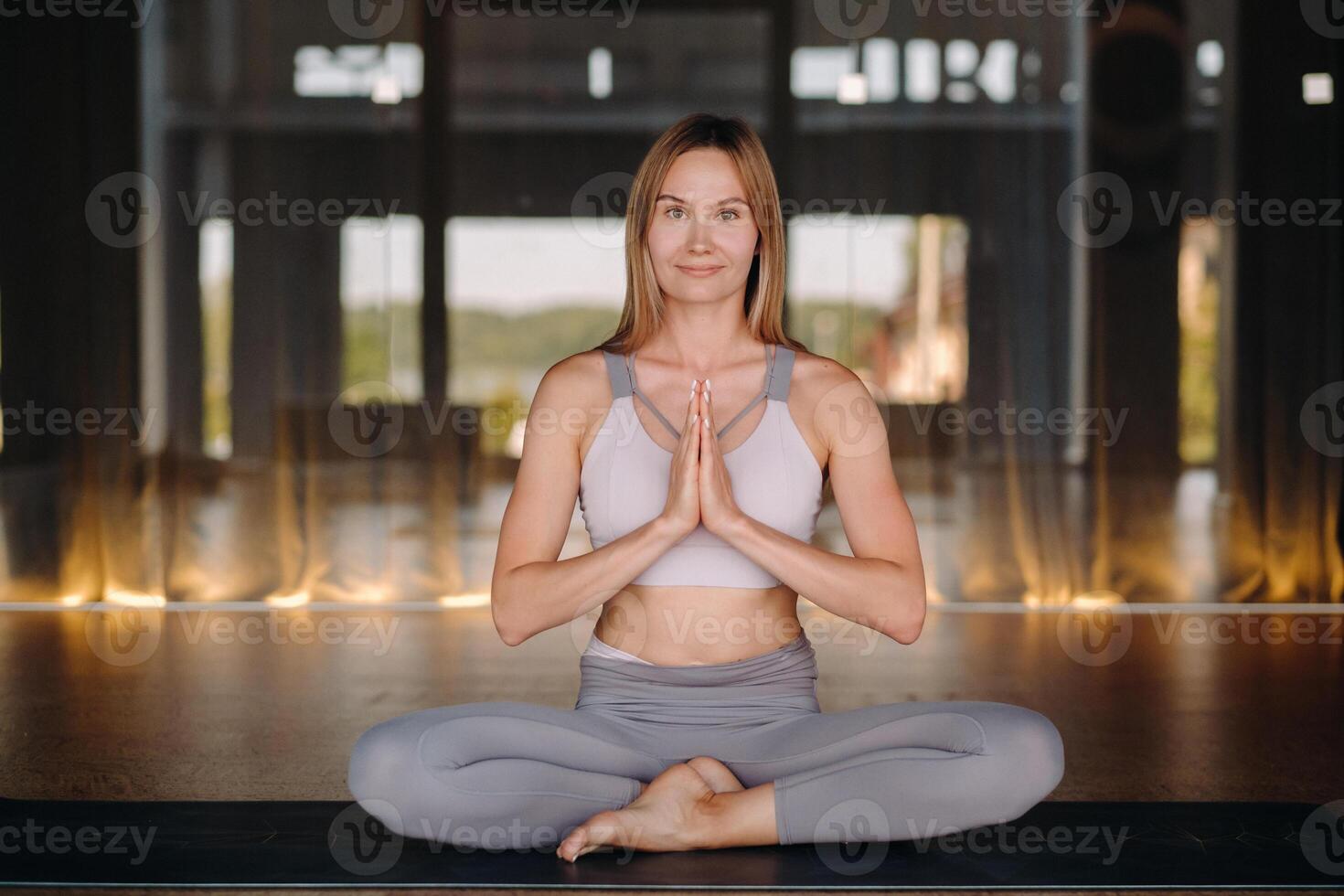 The girl does yoga. A woman in sports clothes does yoga exercises in the gym photo