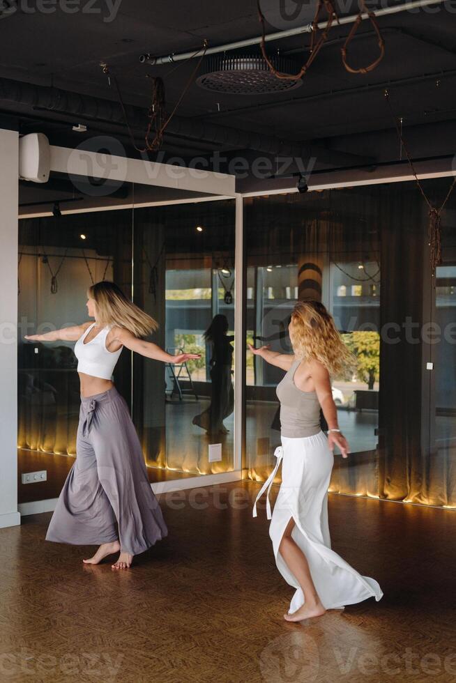 Two women in sportswear are doing dance yoga in the gym photo
