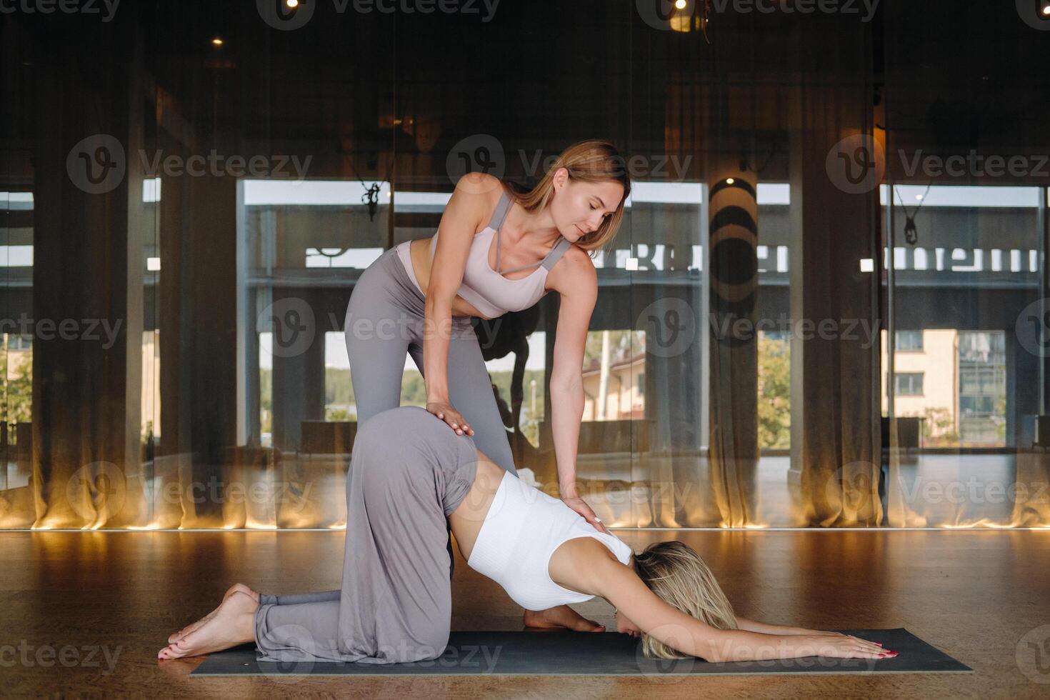 Yoga exercises. A personal trainer teaches a woman yoga classes in the gym photo