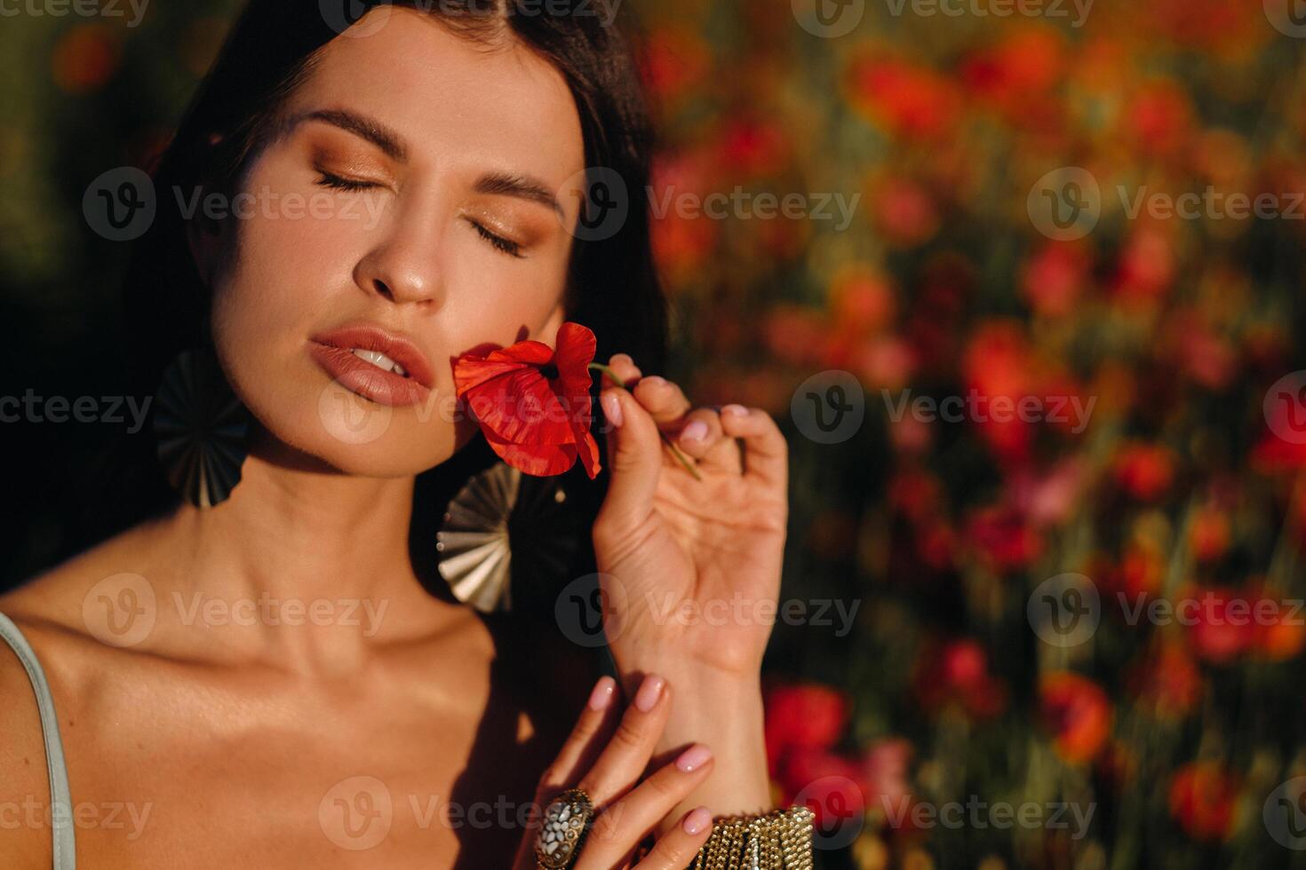 Portrait of a girl in a dress on a poppy field at sunset photo