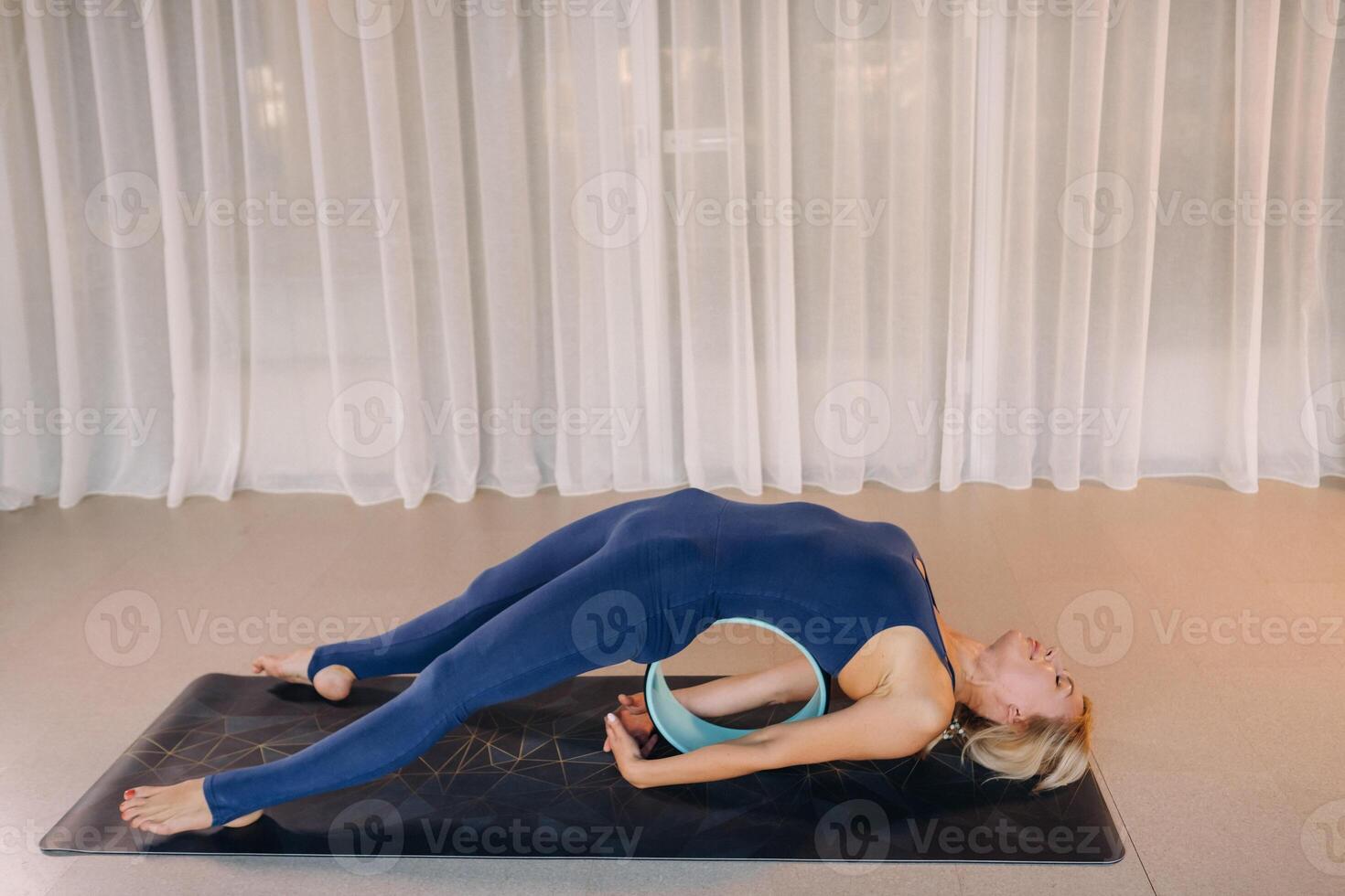 A woman does yoga with a Pilates ring, stretching the body, meditating training softness photo