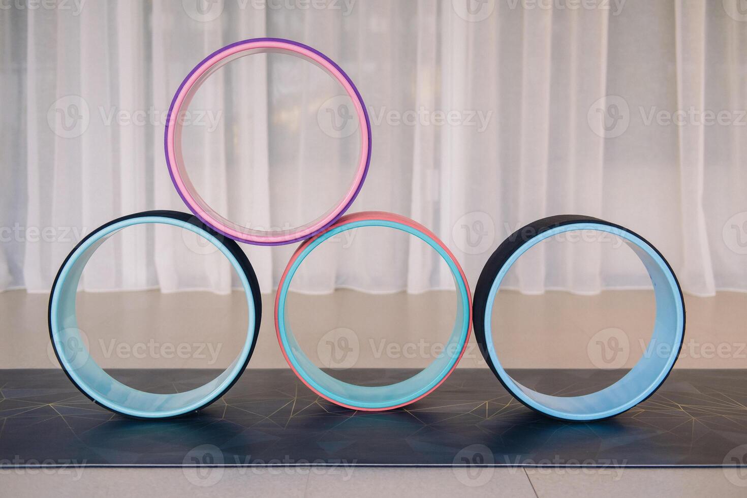 a set of yoga wheels lying on the mat. Fitness Equipment Pilates Ring for Balance and Flexibility Training photo