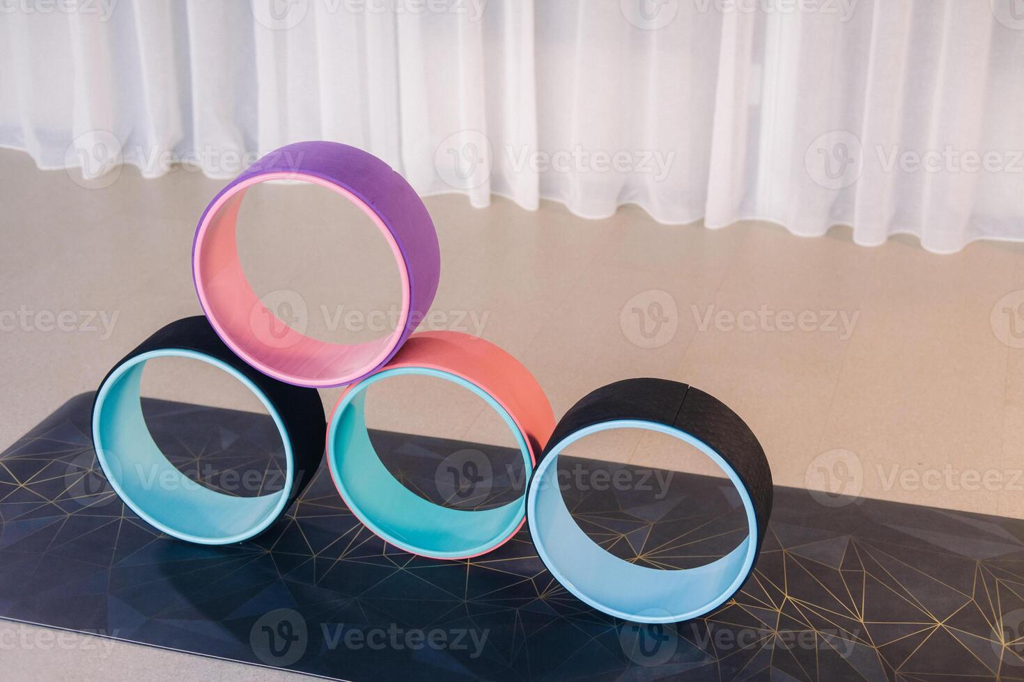 a set of yoga wheels lying on the mat. Fitness Equipment Pilates Ring for Balance and Flexibility Training photo