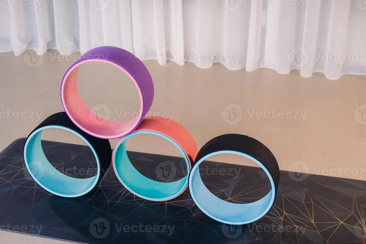 a set of yoga wheels lying on the mat. Fitness Equipment Pilates Ring for Balance and Flexibility Training photo