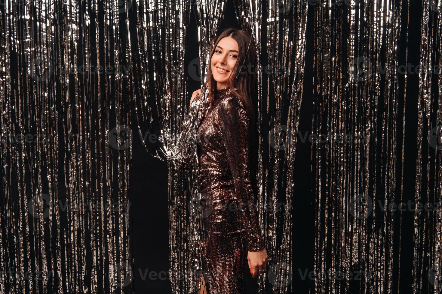 girl in a shiny dress on a silver background of New Year's rain photo