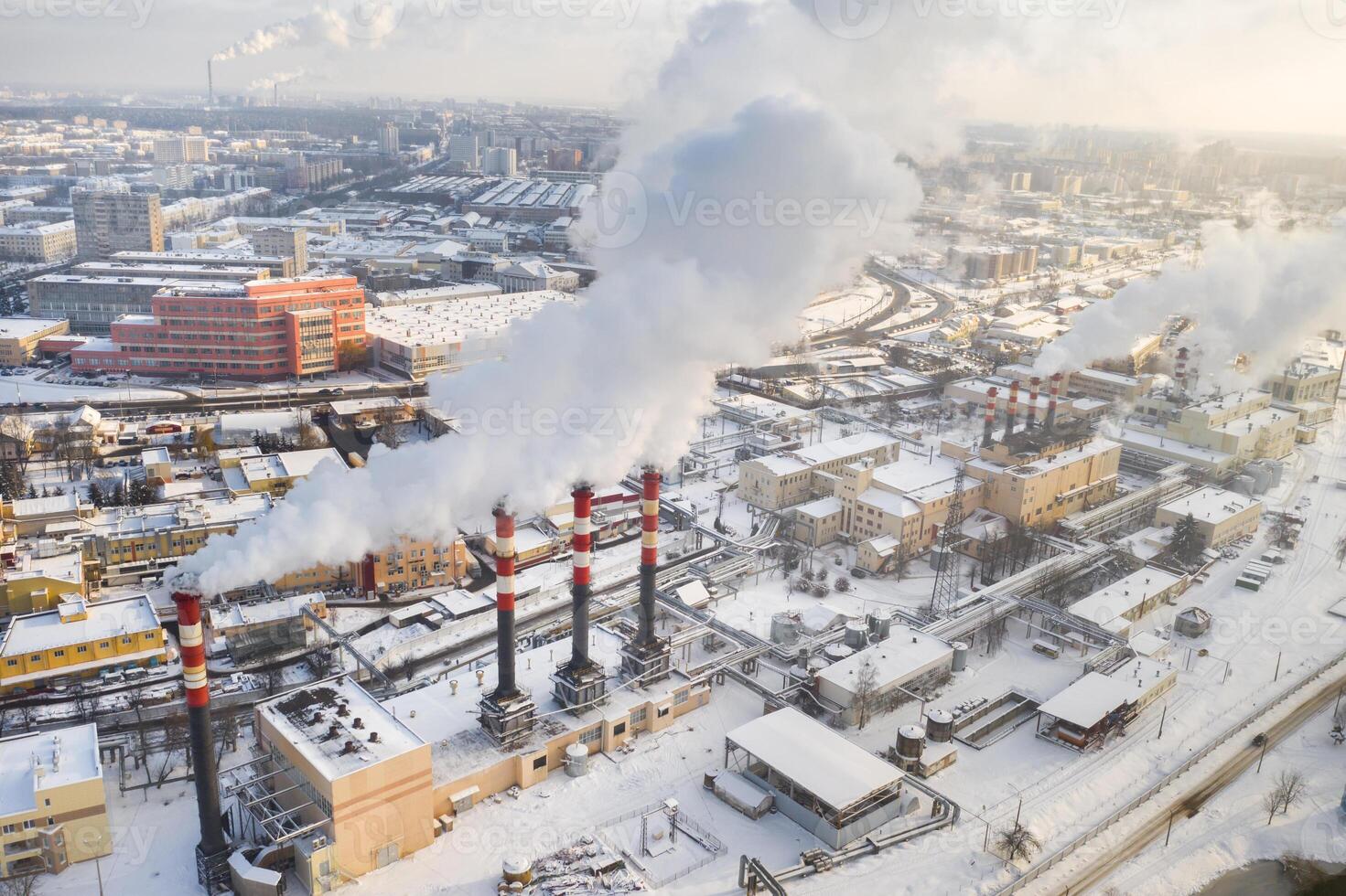 In the winter city, the factory's chimneys are smoking. The concept of air pollution. Environmental pollution by industrial waste photo