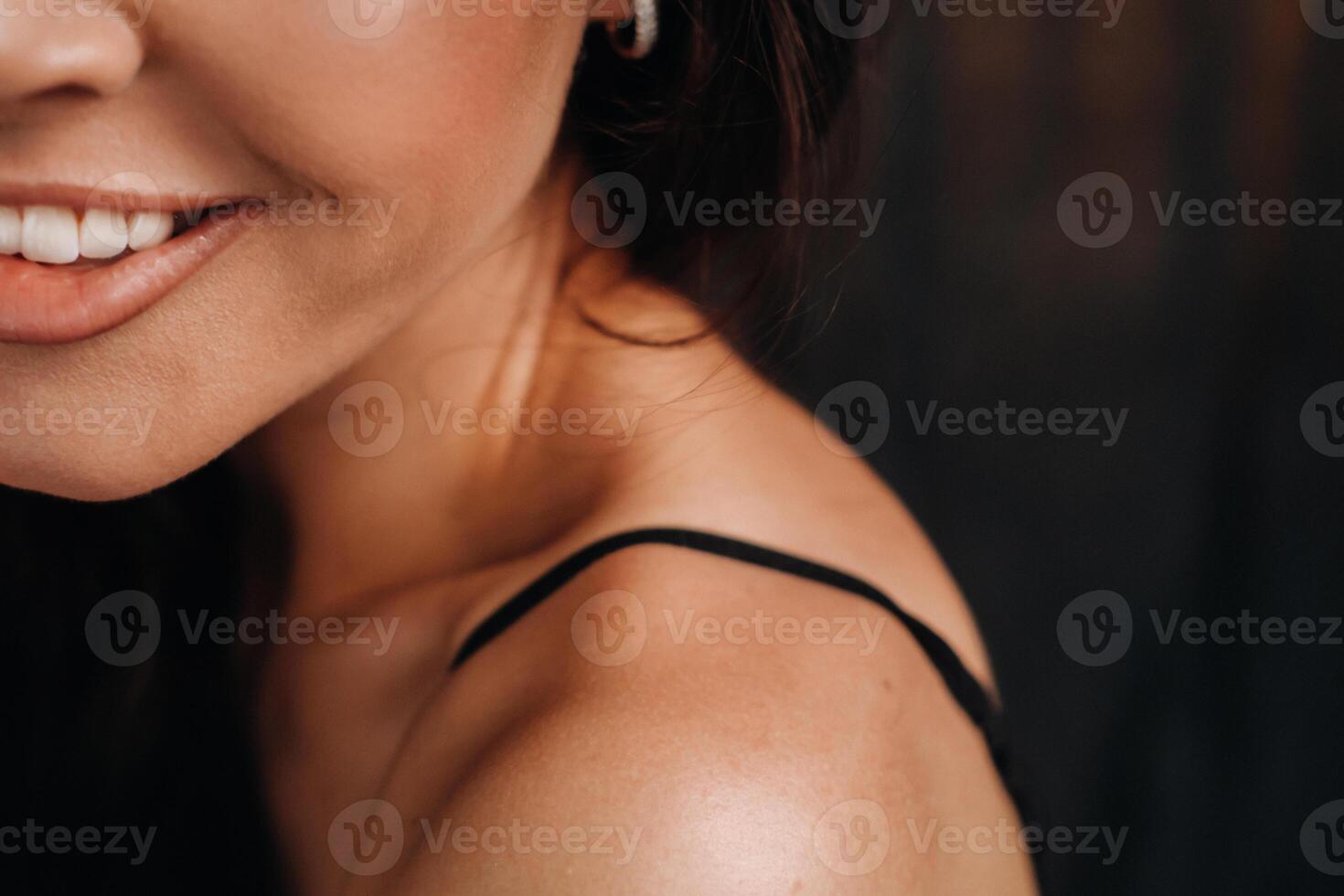 close-up of a girl's face smiling in the studio on a black background photo