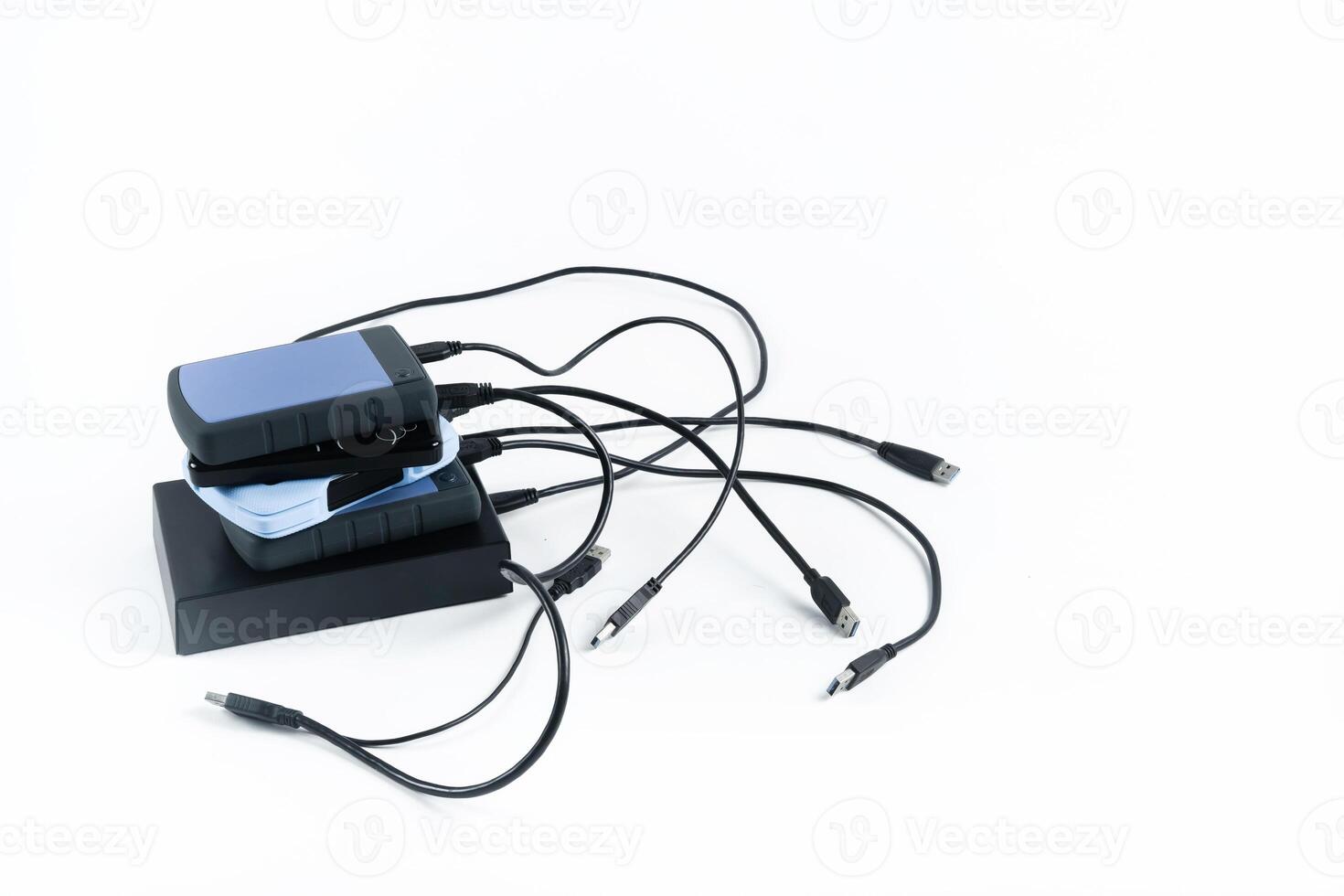 many external hard drives with wires lie on a white background. Hard drives on isolate. photo