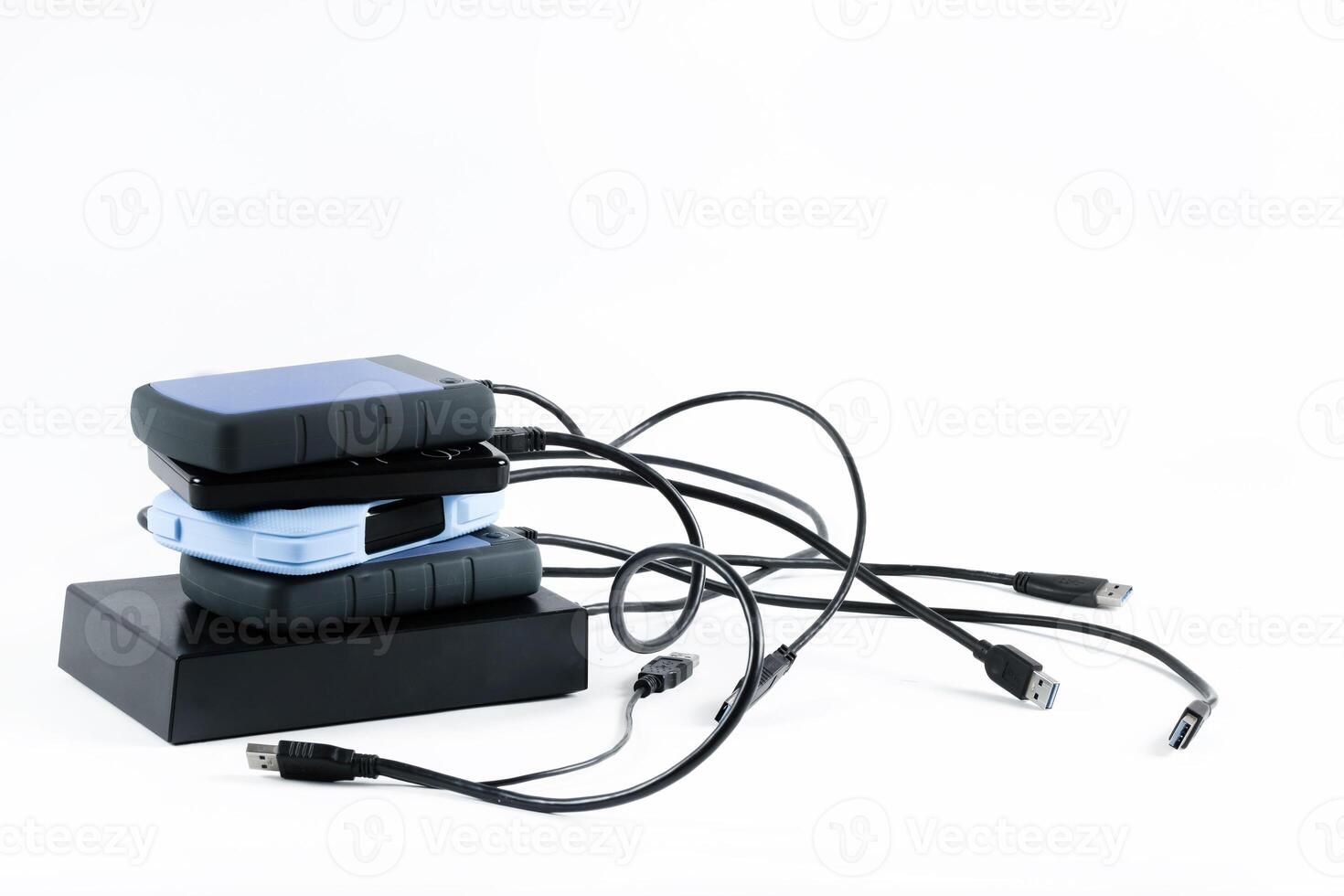 many external hard drives with wires lie on a white background. Hard drives on isolate. photo