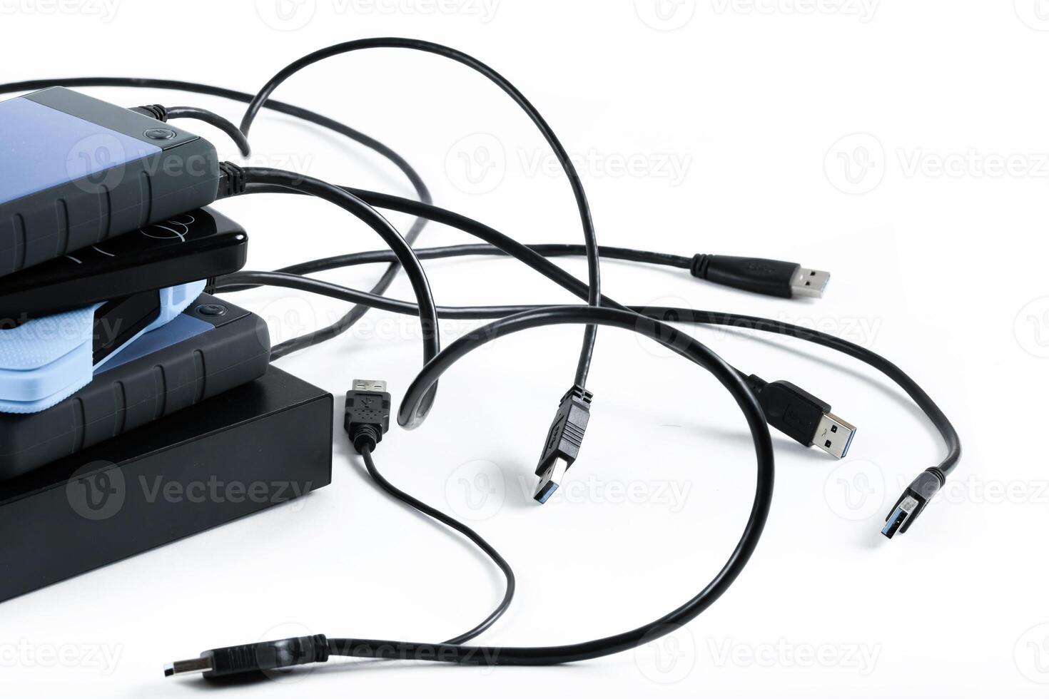 many external hard drives with wires lie on a white background. Hard drives on isolate. photo