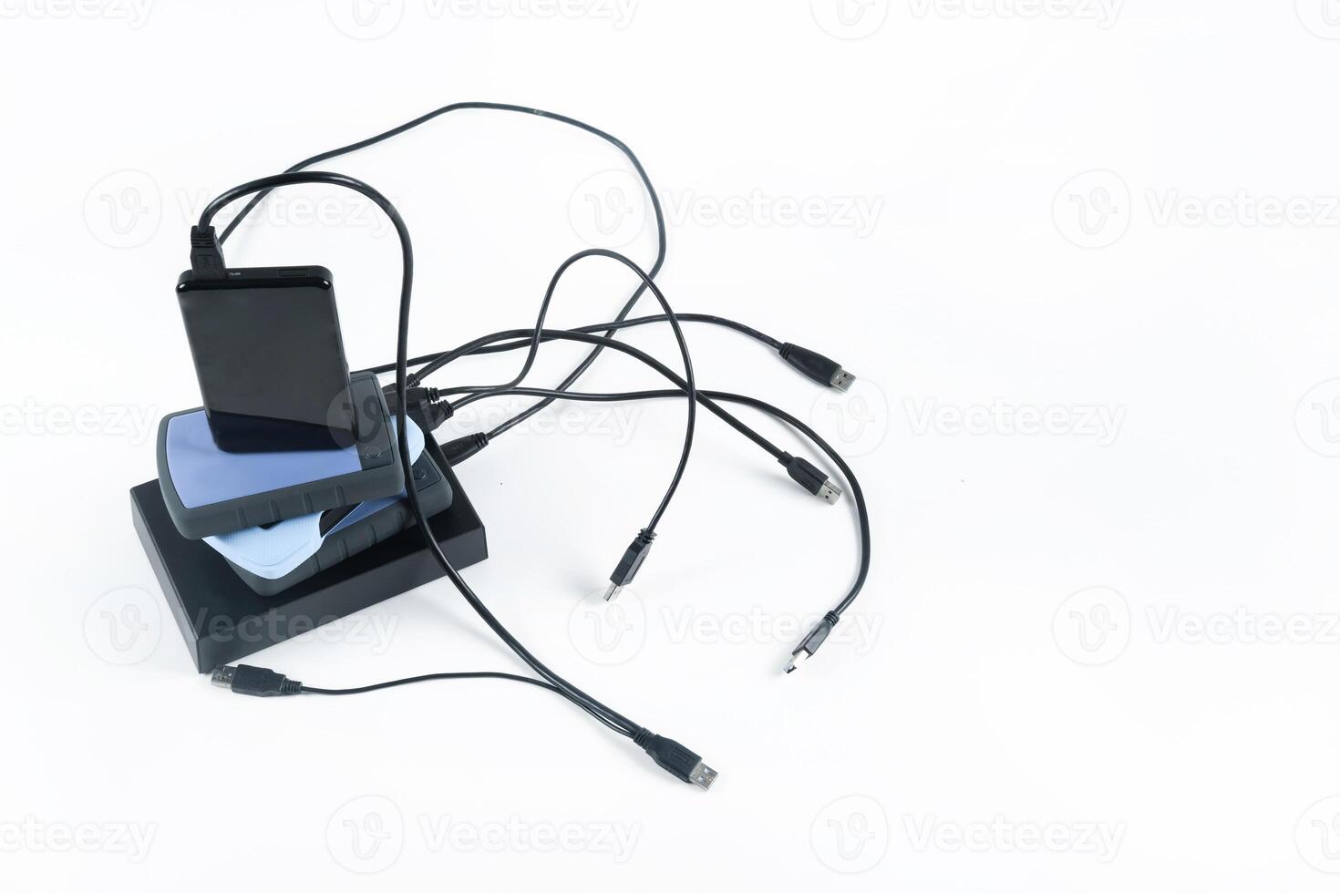 many external hard drives with wires lie on a white background. Hard drives on isolate. photo