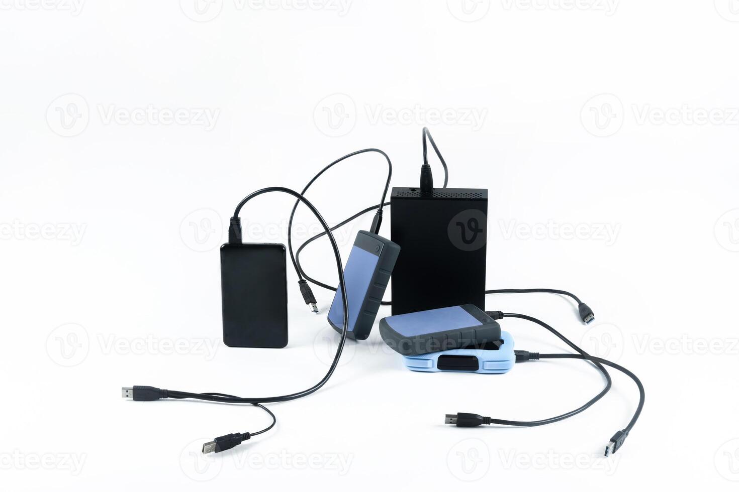 many external hard drives with wires lie on a white background. Hard drives on isolate. photo