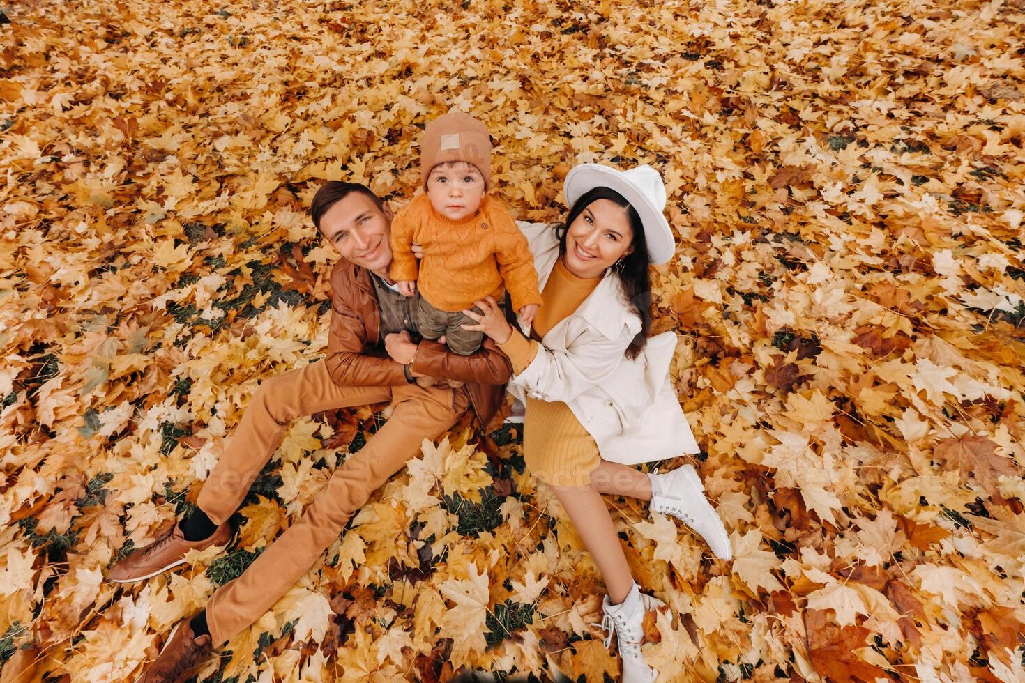 Father and mother with son walking in the autumn Park. A family walks in the Golden autumn in a nature Park. photo