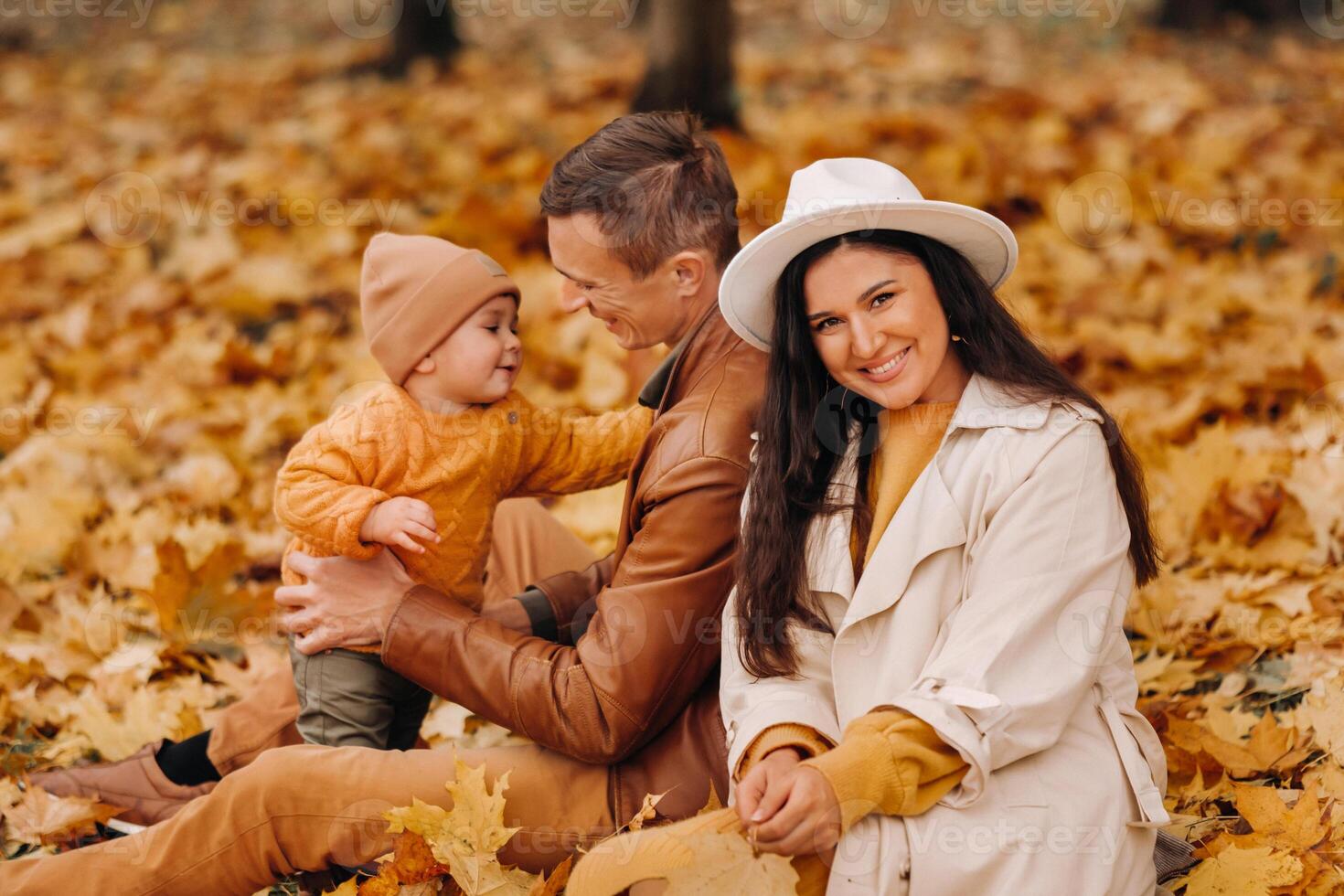 Father and mother with son walking in the autumn Park. A family walks in the Golden autumn in a nature Park. photo