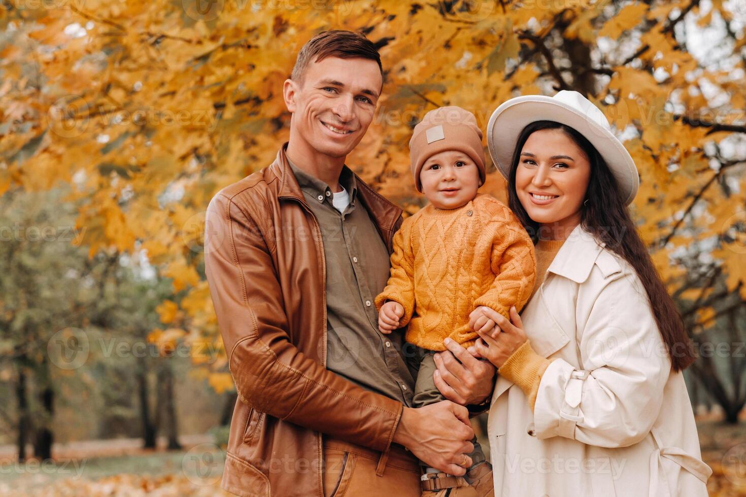 Father and mother with son walking in the autumn Park. A family walks in the Golden autumn in a nature Park. photo