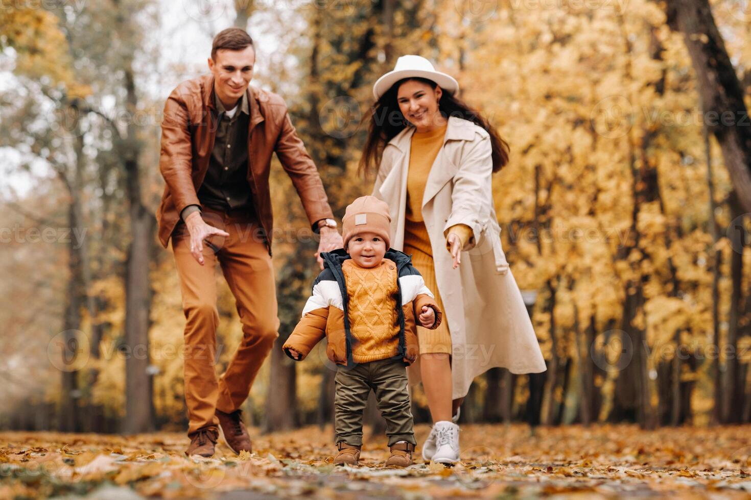 Father and mother with son walking in the autumn Park. A family walks in the Golden autumn in a nature Park. photo