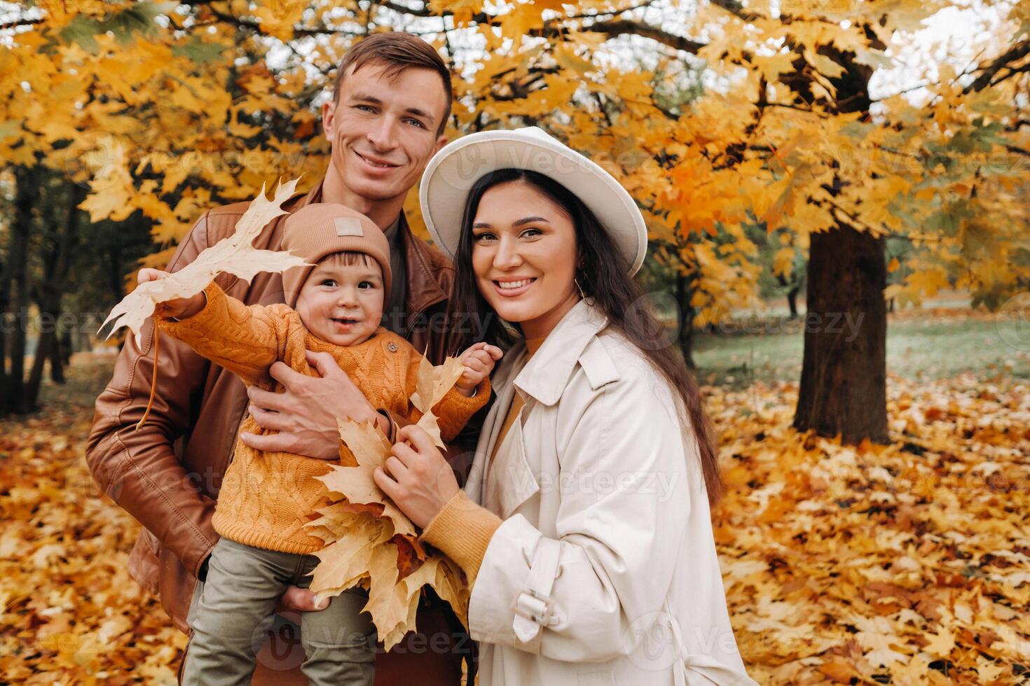 Father and mother with son walking in the autumn Park. A family walks in the Golden autumn in a nature Park. photo