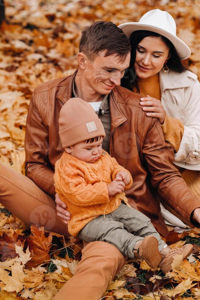 Father and mother with son walking in the autumn Park. A family walks in the Golden autumn in a nature Park. photo
