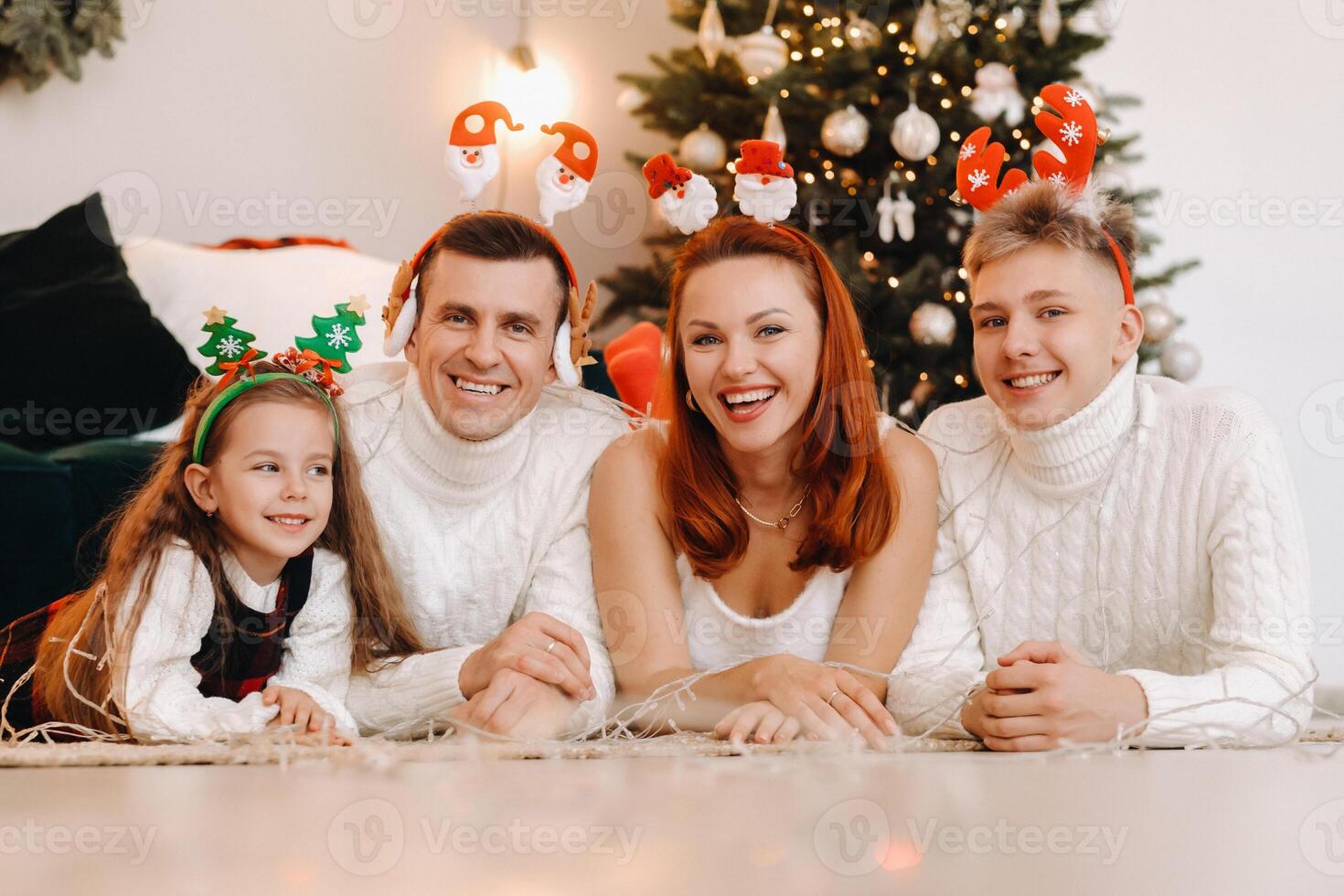 Close-up portrait of a happy family lying near a Christmas tree celebrating a holiday photo