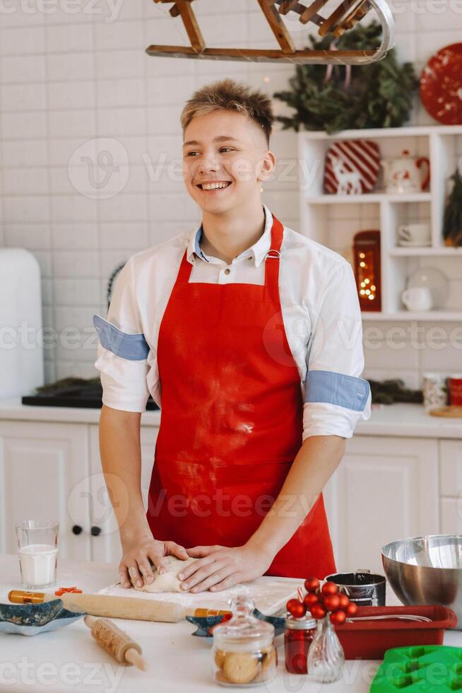 A male chef prepares dough in the Christmas kitchen before the New year photo