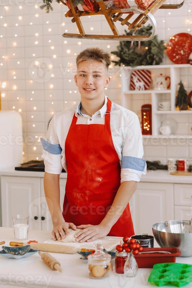 A male chef prepares dough in the Christmas kitchen before the New year photo