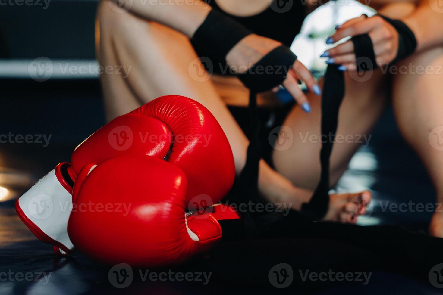 Close-up of red boxing gloves on the floor of a blue boxing ring photo