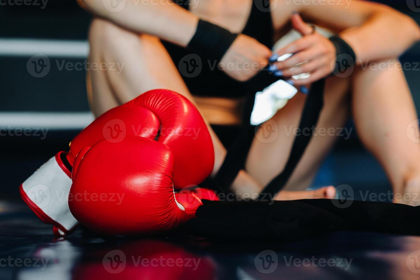 Close-up of red boxing gloves on the floor of a blue boxing ring photo