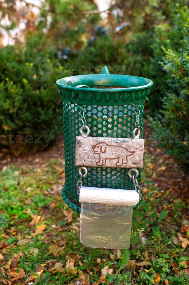 Trash can with a picture of a dog and bags for excrement photo