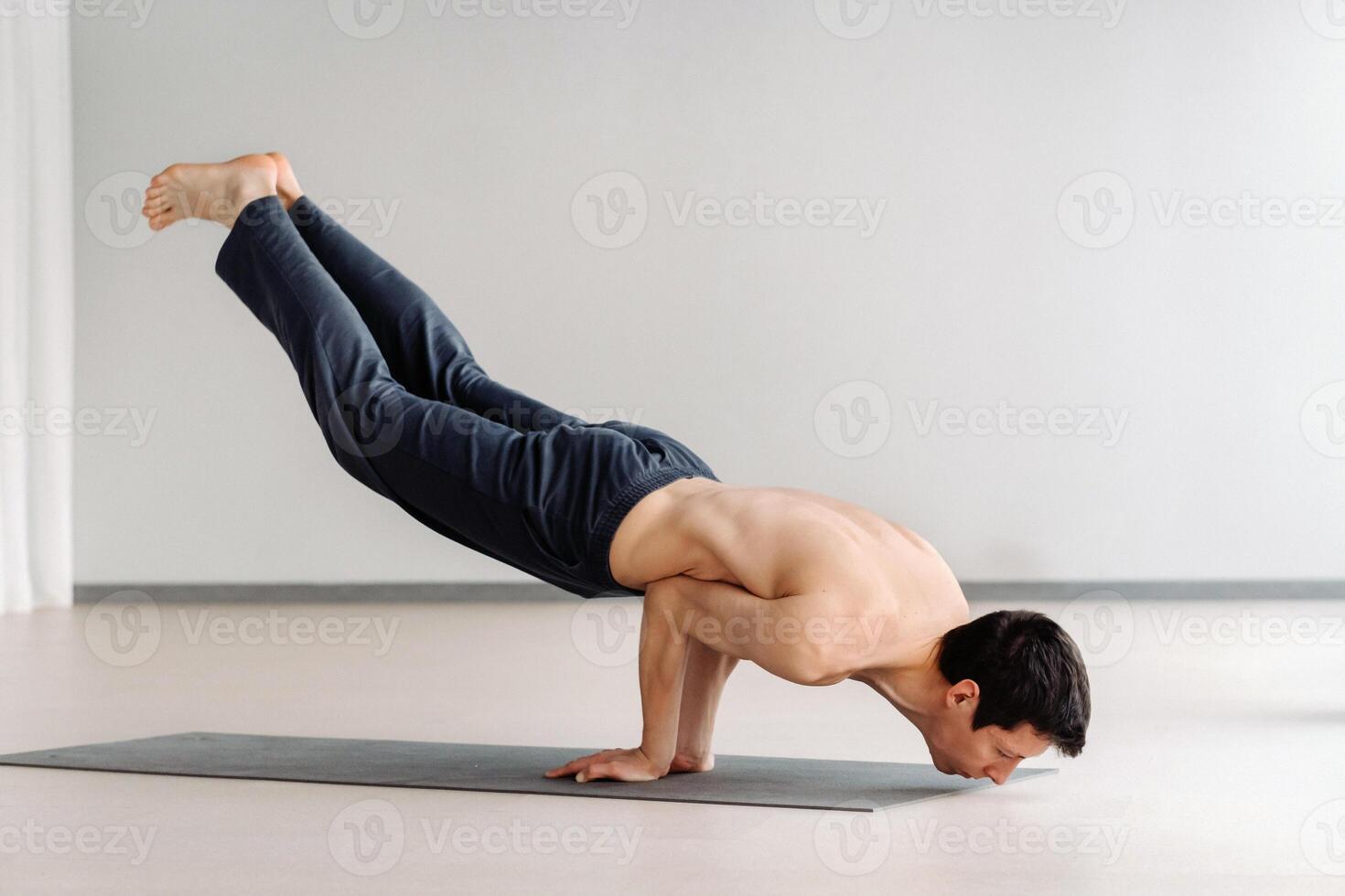 A man with a bare torso trains lying down, doing stretching in the gym photo