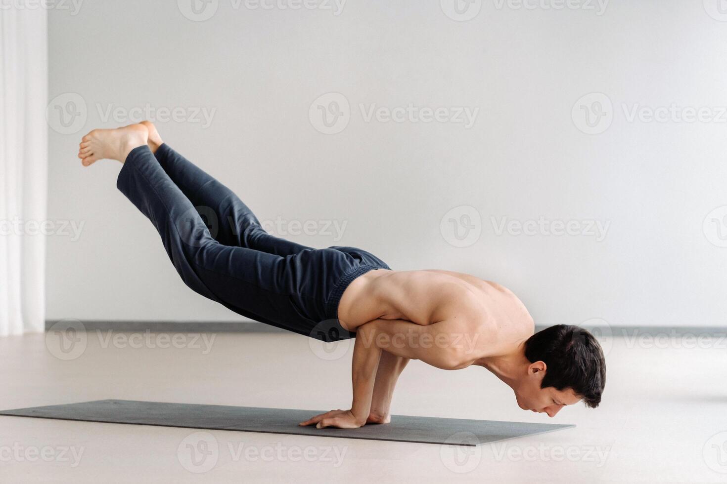 A man with a bare torso trains lying down, doing stretching in the gym photo