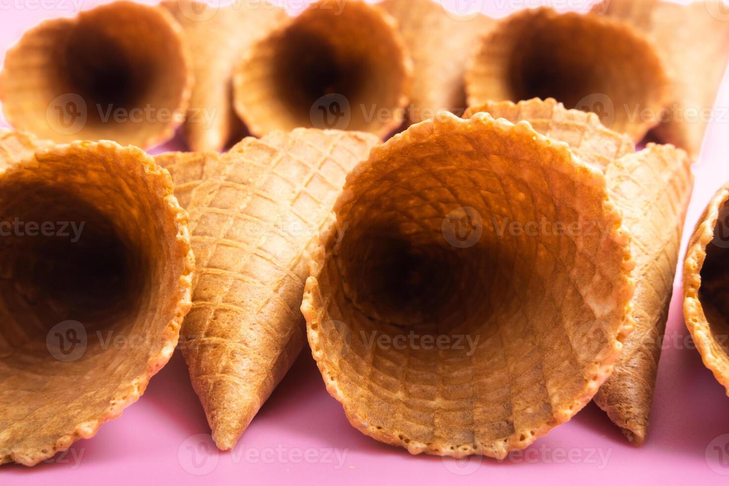 Empty waffle cones for ice cream on a pink background photo