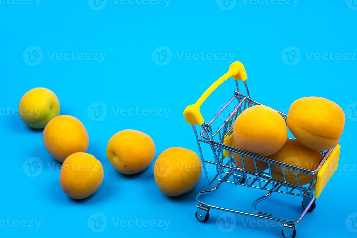 Shopping basket with apricots on a blue background.Shopping cart photo