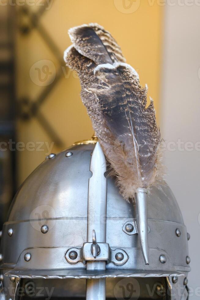 An ancient knight's helmet with a feather .Medieval concept photo