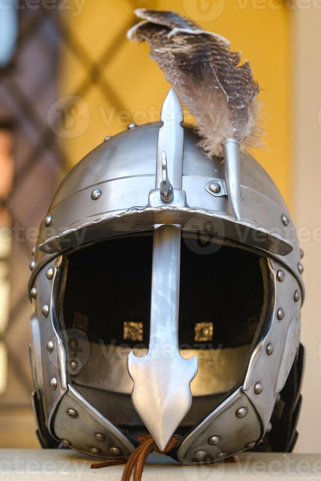 An ancient knight's helmet with a feather .Medieval concept photo