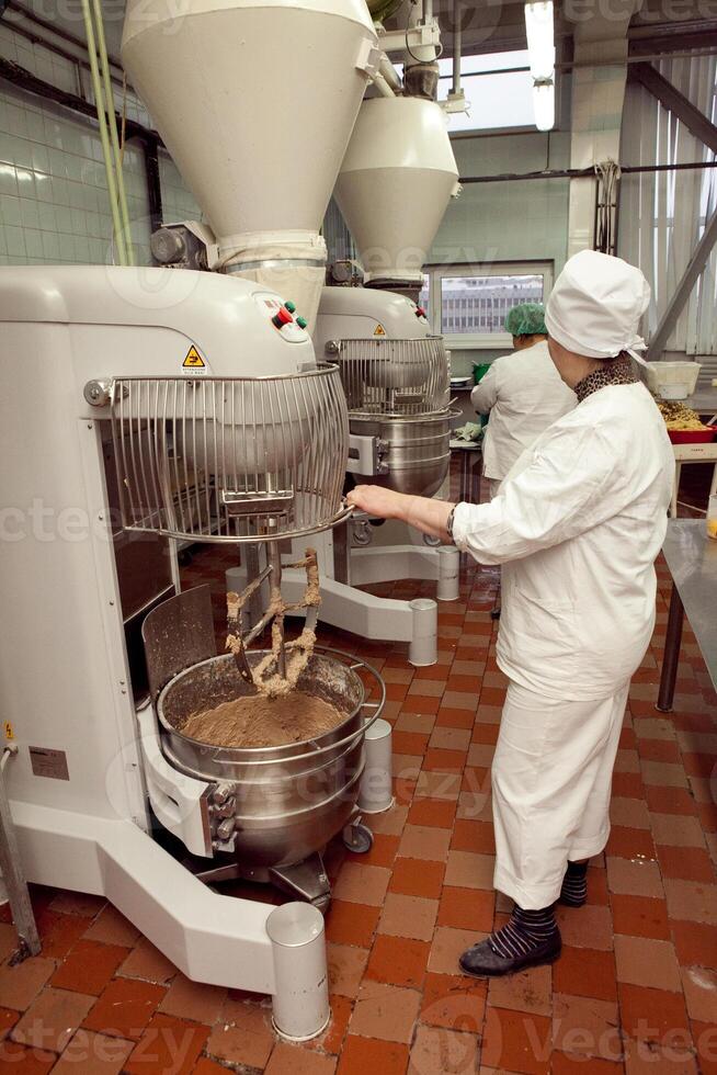 The process of making cookie dough in an industrial kneading machine at the factory photo